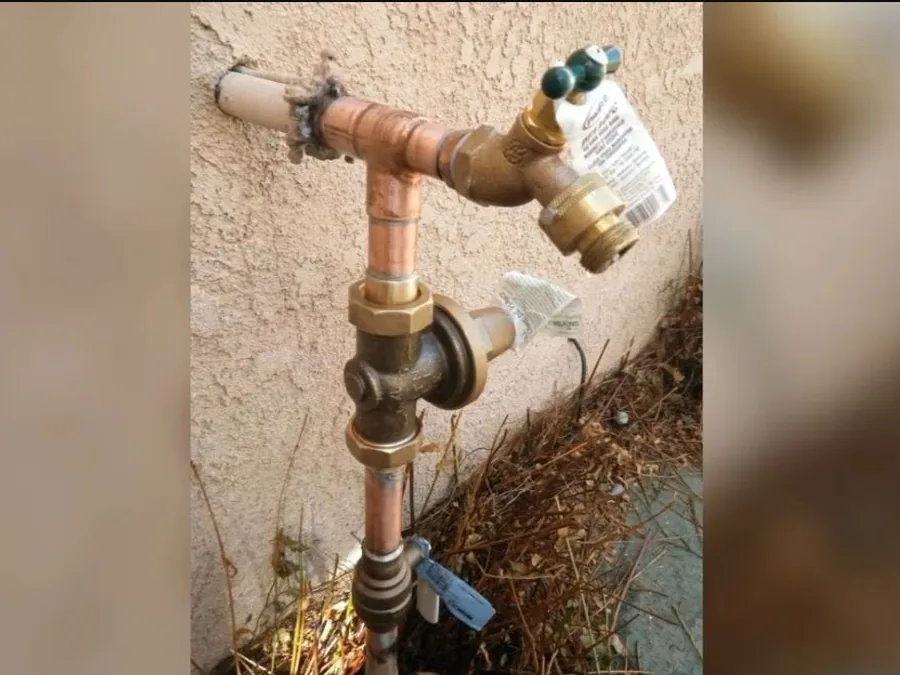 Wall-mounted anti-siphon hose bib installed outside a home