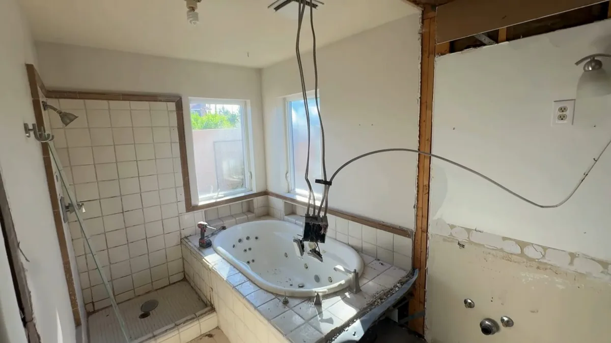 Bathroom remodel with wall framing exposed for rough plumbing work