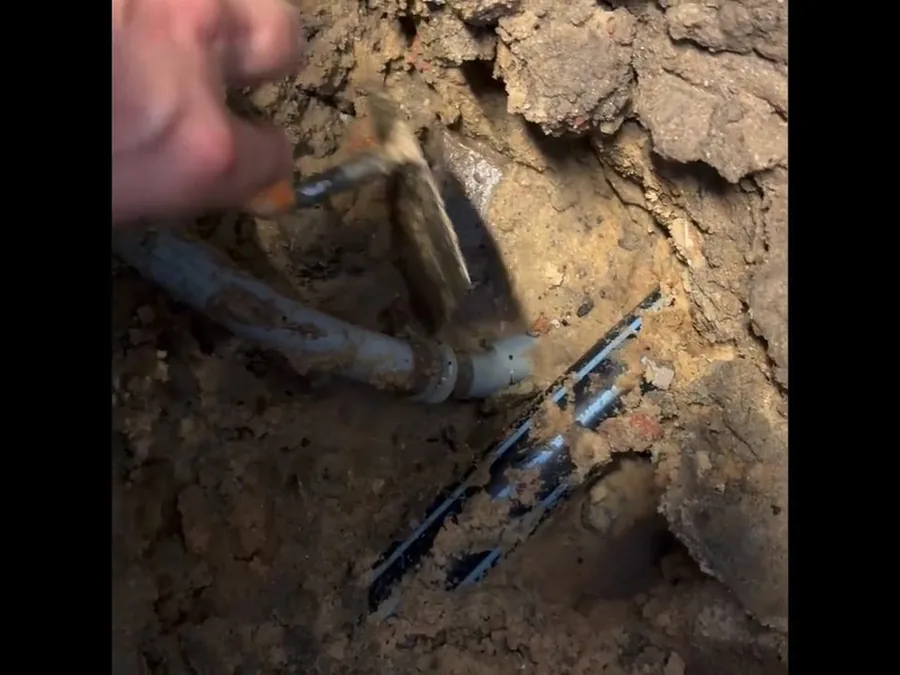 Concrete slab opening around a damaged pipe during burst pipe repair