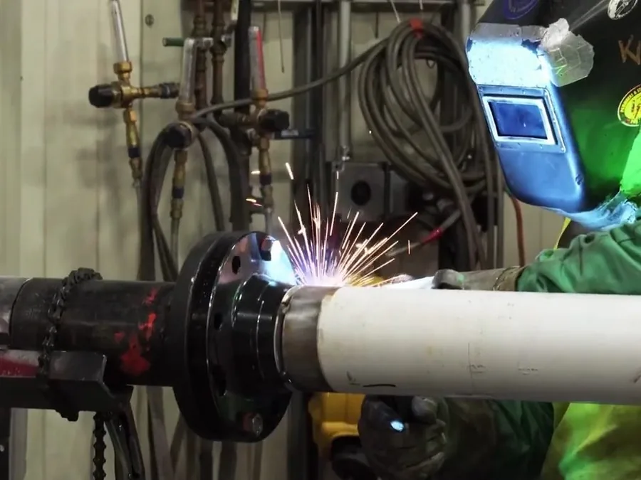 Worker welding or joining commercial plumbing pipe during installation