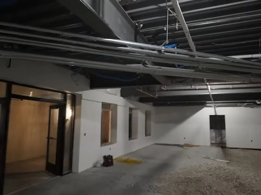 Commercial plumbing rough-in layout marked across an open concrete floor