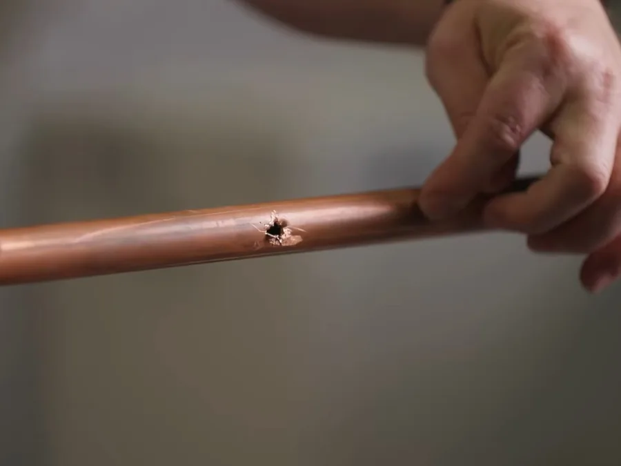 Copper pipe with a small hole being prepared for leak repair
