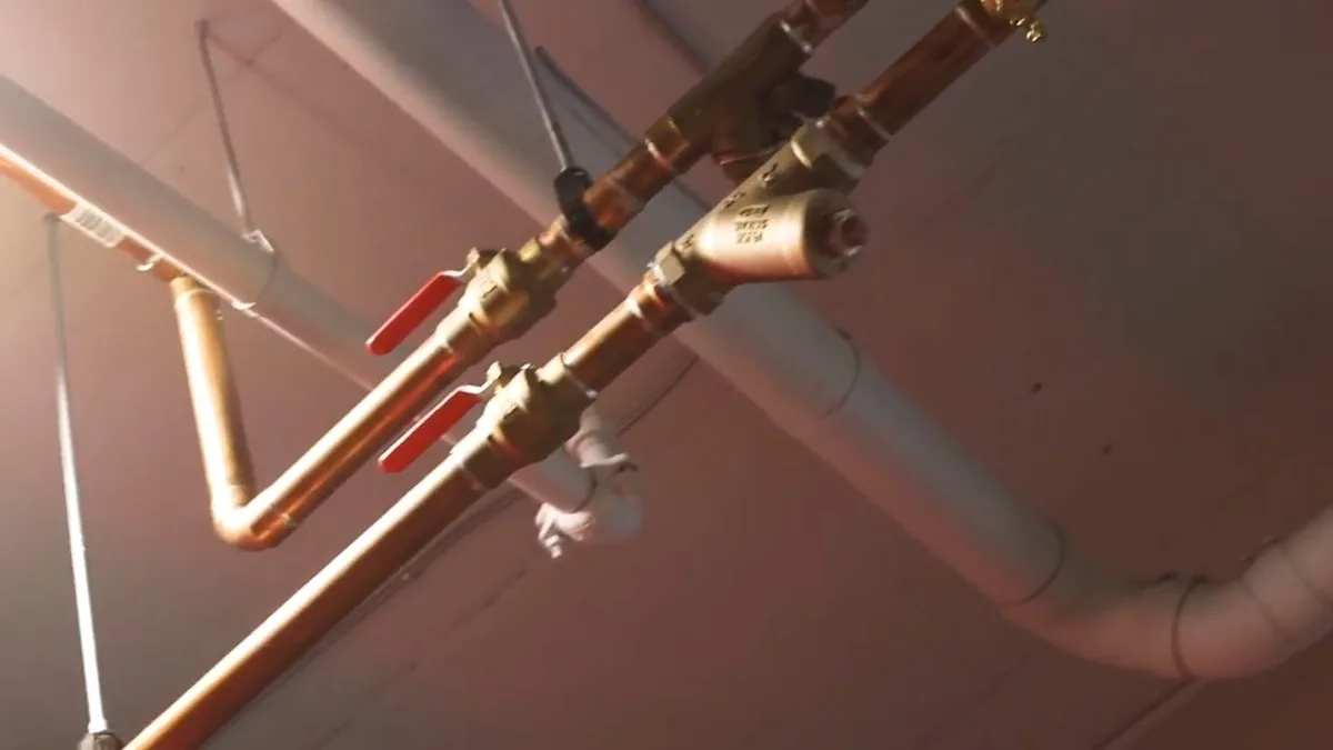 New copper supply lines routed along an exposed bathroom wall during repiping