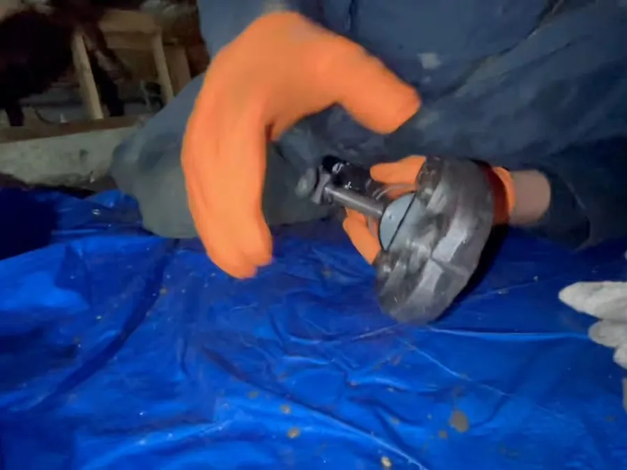 Technician inspecting a pipe connection in a crawlspace during a home plumbing evaluation
