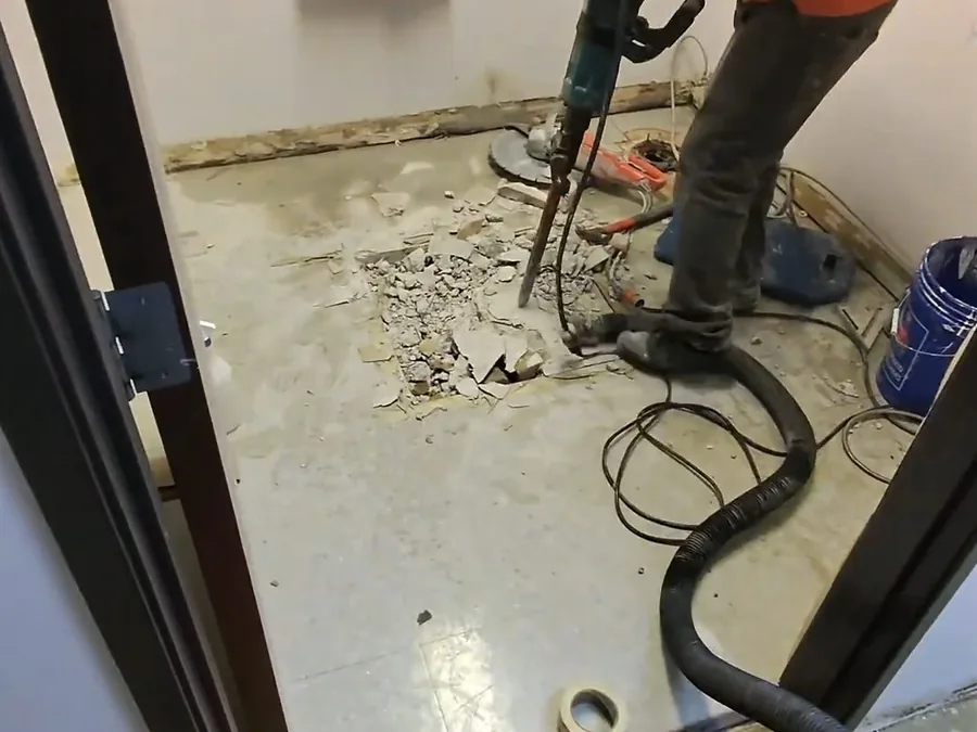 Drain cleaning cable being fed into a bathroom drain line