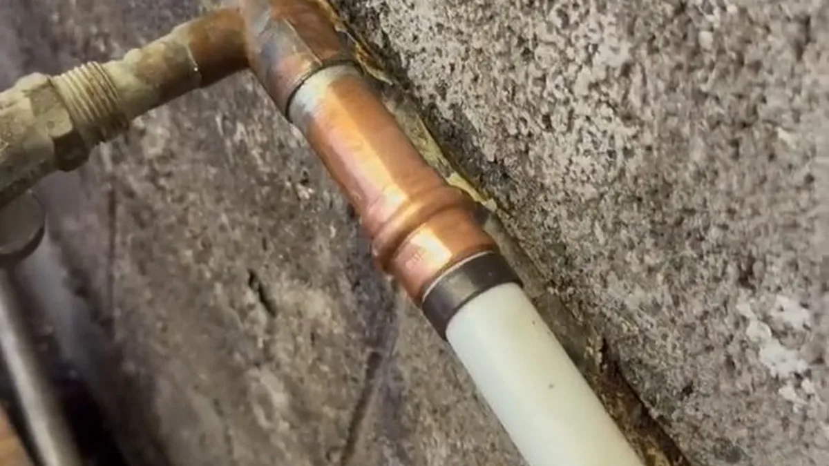 Exposed wall pipe repair area during a residential plumbing service call in Burbank