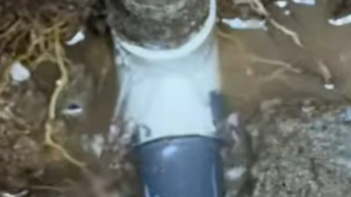 Exposed pipe in a concrete slab access opening during leak repair