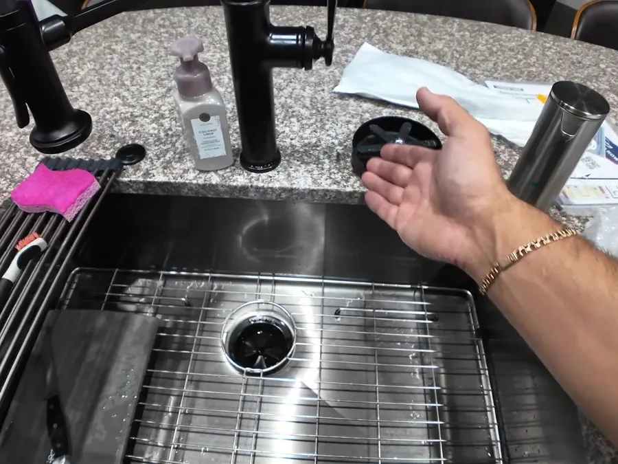 Kitchen sink faucet being installed with the basin and drain opening visible