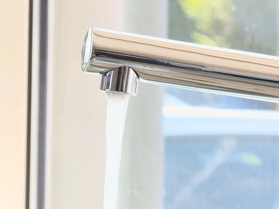 Modern wall-mounted faucet spout above a sink area