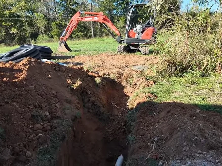 Open trench showing sewer lateral replacement work in a yard