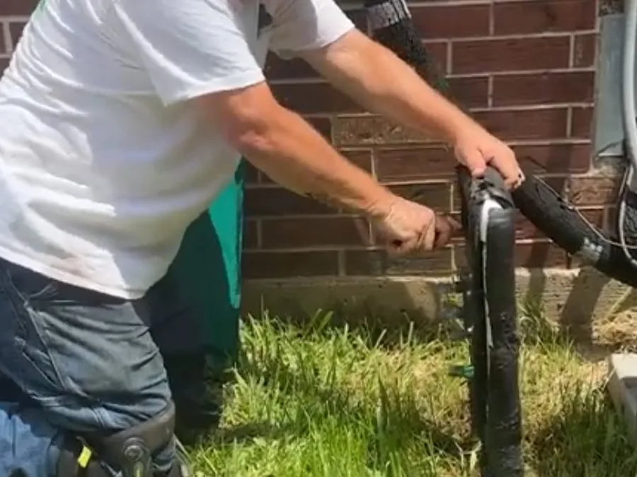 Outdoor faucet repair beside a brick wall and garden hose connection