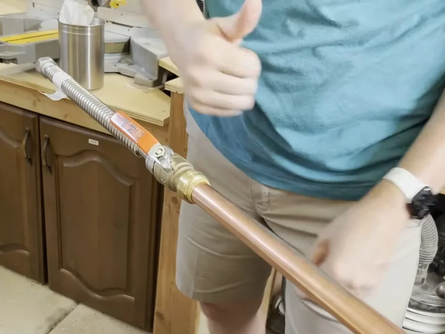 PEX supply line being routed near a kitchen cabinet during repipe work