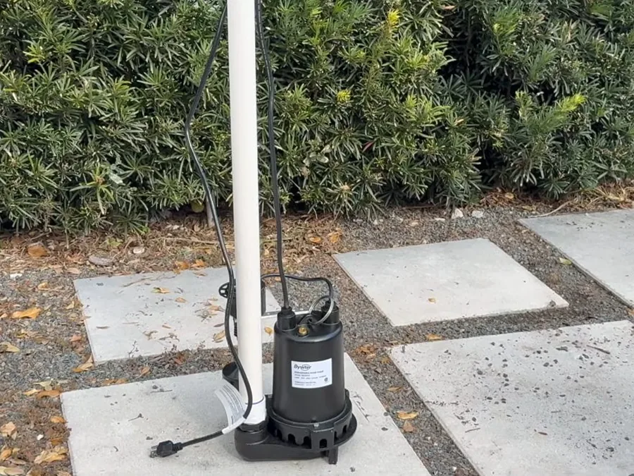 Outdoor equipment pad with plumbing connected near a pool or drainage system