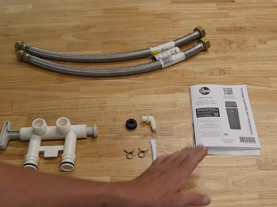 Water softener installation parts laid out before assembly