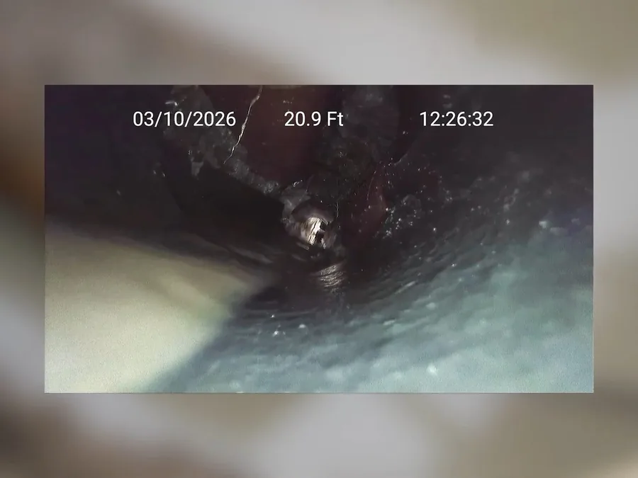 Sewer inspection camera monitor showing obstruction inside a drain line
