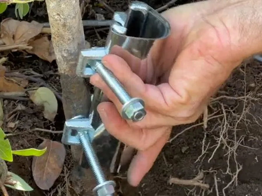 Outdoor sprinkler pipe fitting being repaired near landscaping