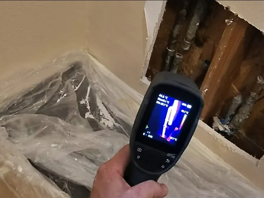 Thermal camera pointed at an open wall cavity during a residential leak check in La Cañada Flintridge