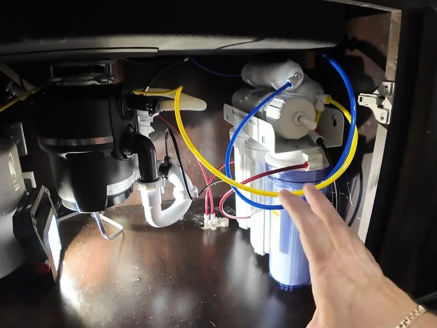 Under-sink garbage disposal wiring and drain assembly being checked
