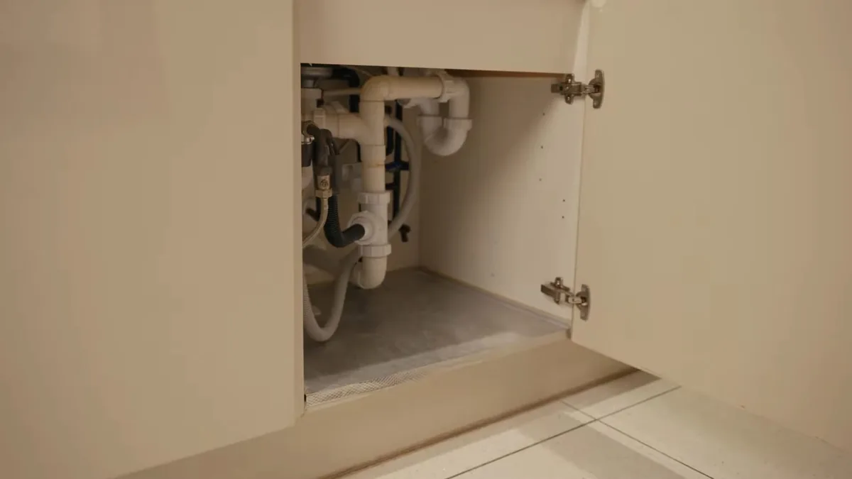 Under-sink water filter connections below a kitchen cabinet in a Pasadena home