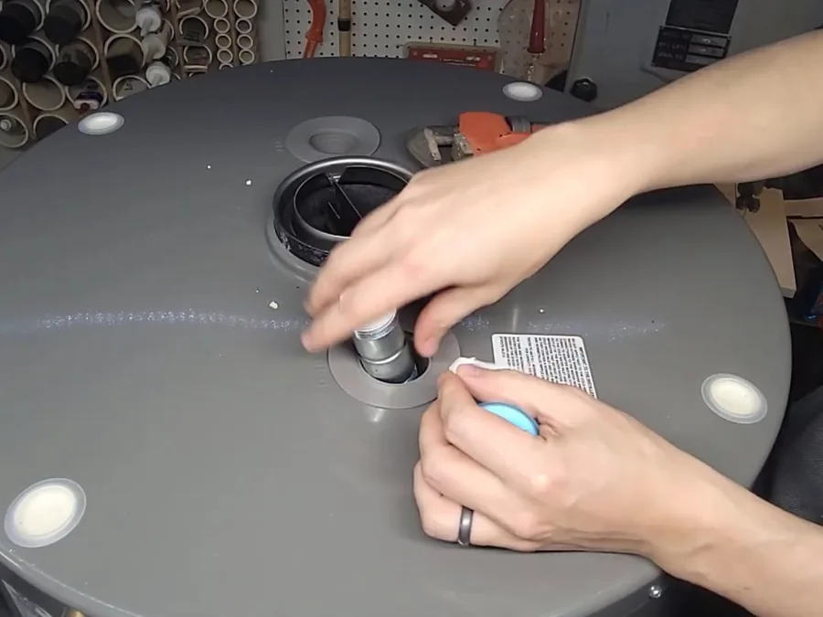 Gas water heater installation with tank connections being assembled