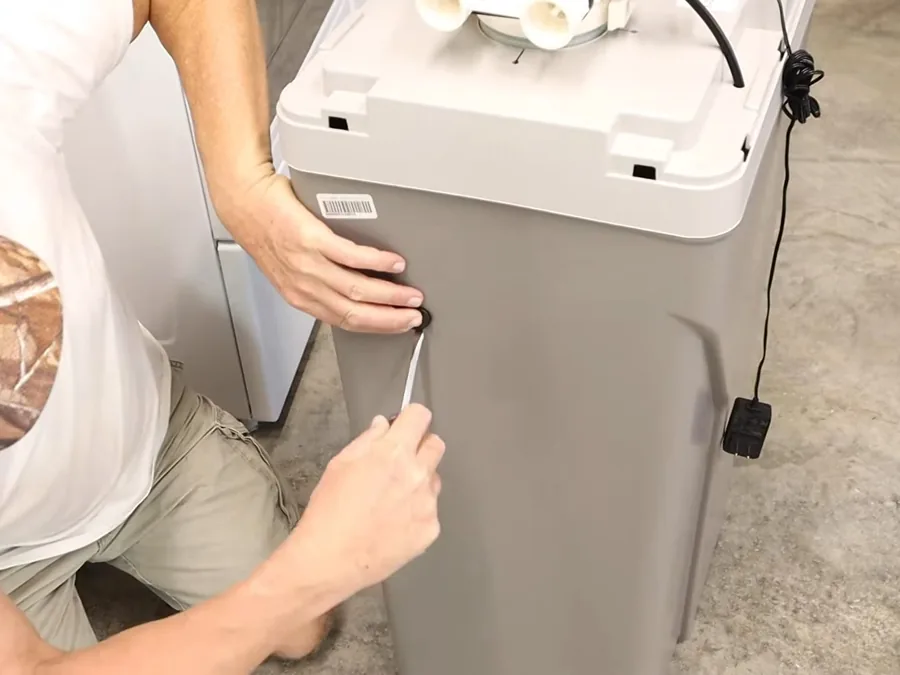 Water softener tank connections being tightened during installation